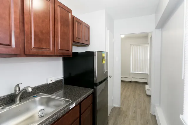 a kitchen with stainless steel appliances granite countertop a sink refrigerator and microwave