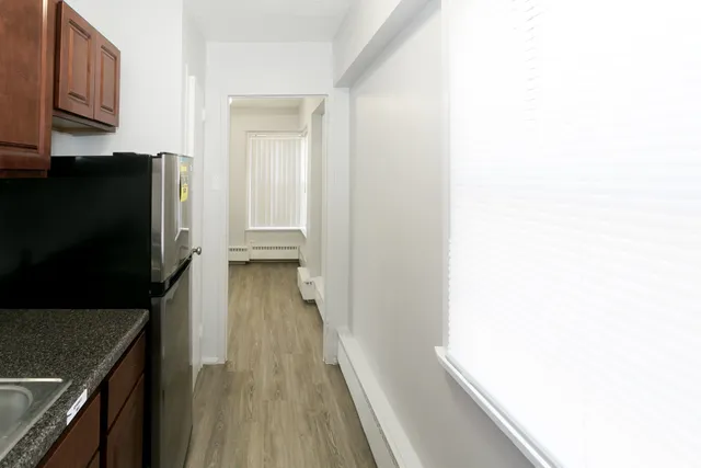 a view of a hallway with wooden floor and staircase