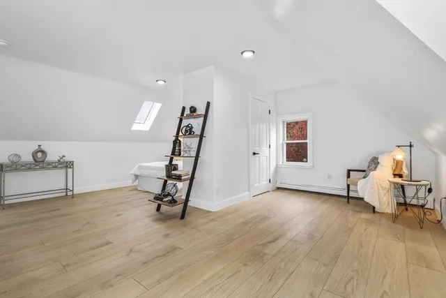 a view of an empty room with furniture and a window