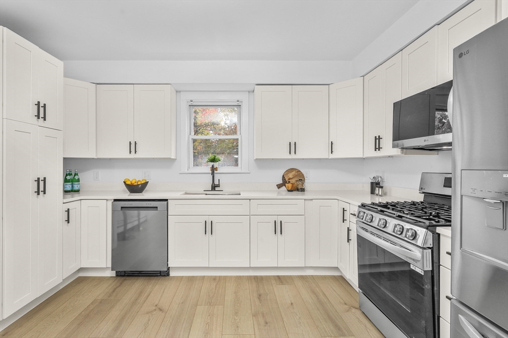 25 Ladd Street, Unit 25 Watertown, MA 02472 - Photo 2 of 16 a kitchen with white cabinets stainless steel appliances and a sink