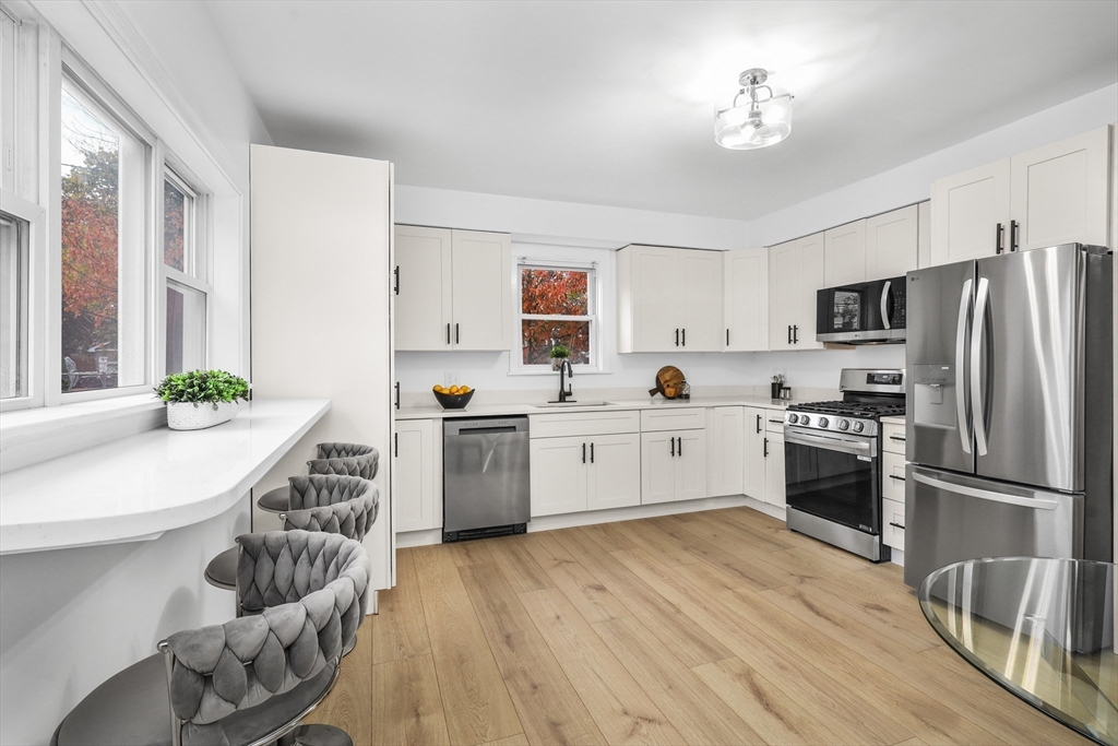 25 Ladd Street, Unit 25 Watertown, MA 02472 - Photo 3 of 16 a kitchen with granite countertop stainless steel appliances and wooden cabinets