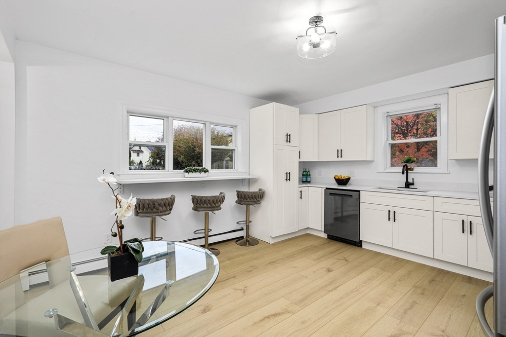 25 Ladd Street, Unit 25 Watertown, MA 02472 - Photo 5 of 16 a kitchen with granite countertop a sink cabinets stainless steel appliances and a window