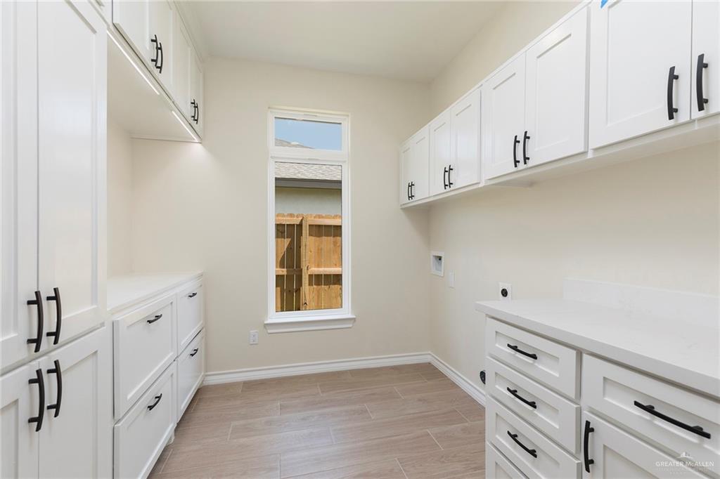 8030 North 50th Street McAllen, TX 78504 - Photo 15 of 23 Washroom with cabinet space, wood finish floors, hookup for a washing machine, and hookup for an electric dryer