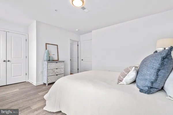 a spacious bedroom with a bed and a wooden floor