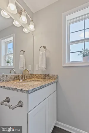 a bathroom with a granite countertop sink a large mirror and vanity
