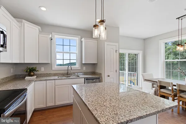 a kitchen with stainless steel appliances granite countertop a sink dishwasher stove refrigerator and cabinets