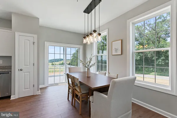 a dining room with furniture a chandelier and wooden floor