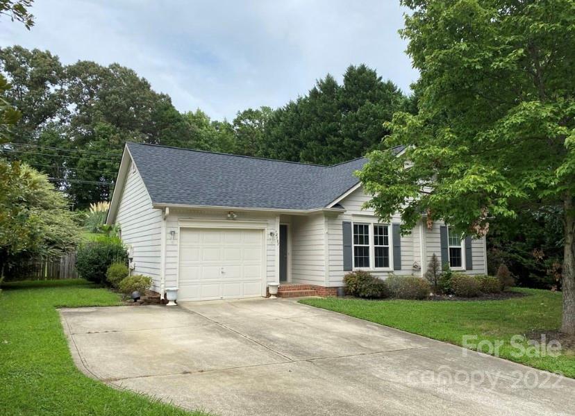 a view of a house with a yard and tree