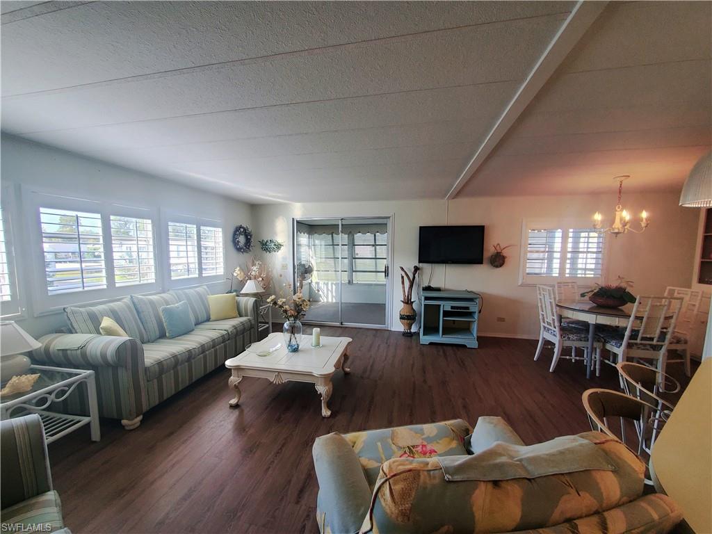 4 Topaz Lane, Unit T4 Naples, FL 34112 - Photo 2 of 17 a living room with furniture and a flat screen tv