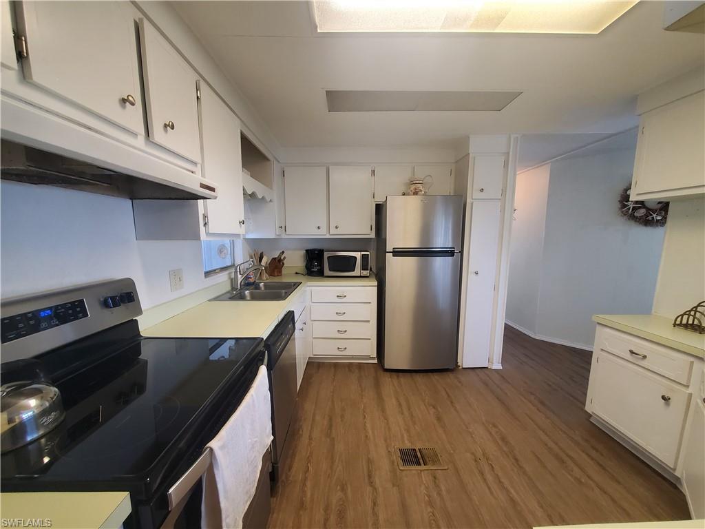 4 Topaz Lane, Unit T4 Naples, FL 34112 - Photo 3 of 17 a kitchen with a refrigerator stove and wooden cabinets