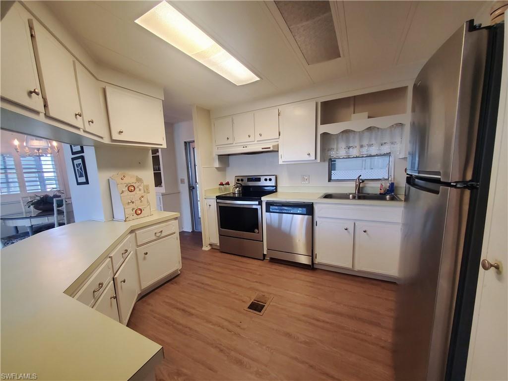 4 Topaz Lane, Unit T4 Naples, FL 34112 - Photo 5 of 17 a kitchen with granite countertop a refrigerator stove top oven and sink