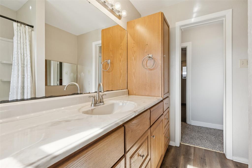 10609 Seagoville Road Dallas, TX 75217 - Photo 19 of 33 a bathroom with a granite countertop sink and a mirror