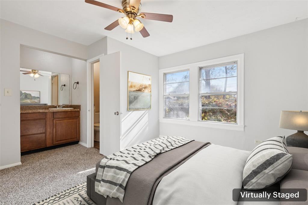 10609 Seagoville Road Dallas, TX 75217 - Photo 22 of 33 a bedroom with a bed and a chandelier