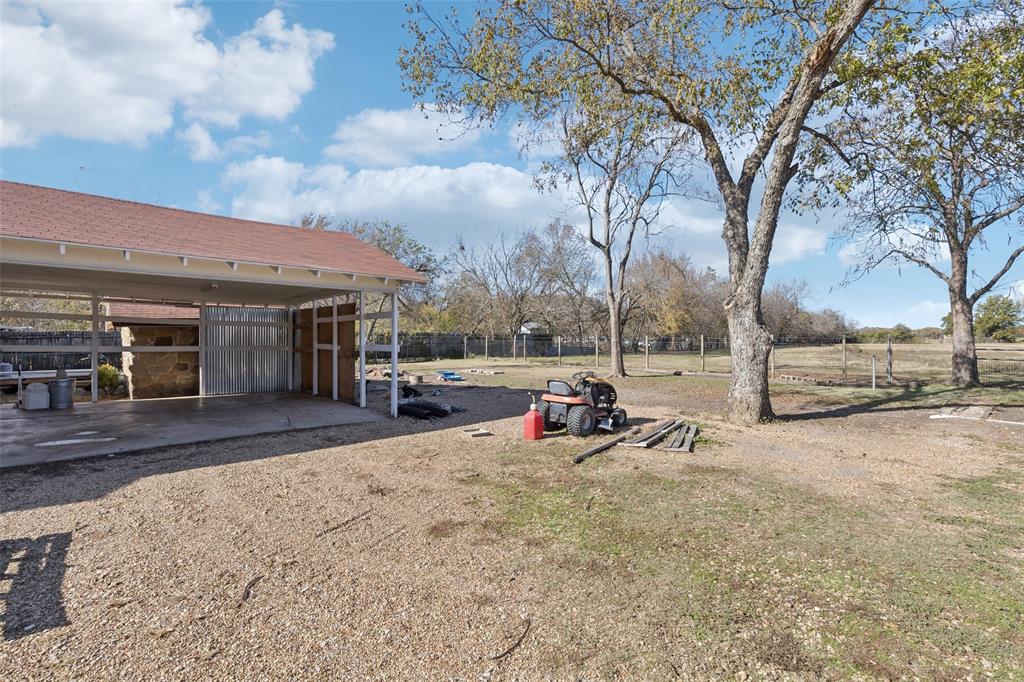 10609 Seagoville Road Dallas, TX 75217 - Photo 27 of 33 a view of a backyard with table and chairs and a large tree