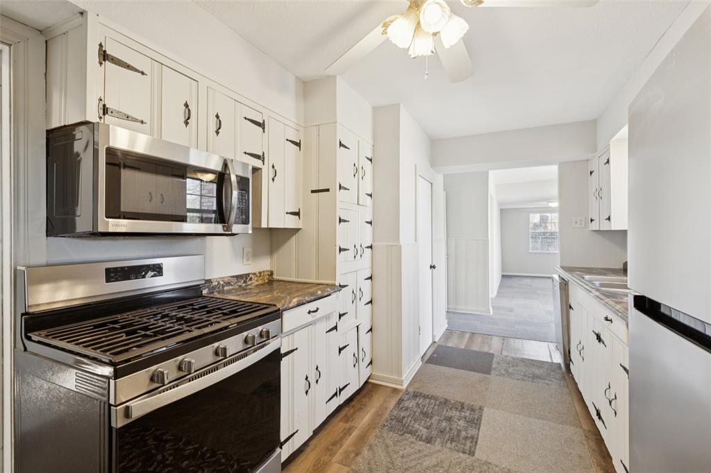 10609 Seagoville Road Dallas, TX 75217 - Photo 9 of 33 a kitchen with stainless steel appliances a stove a sink and a refrigerator