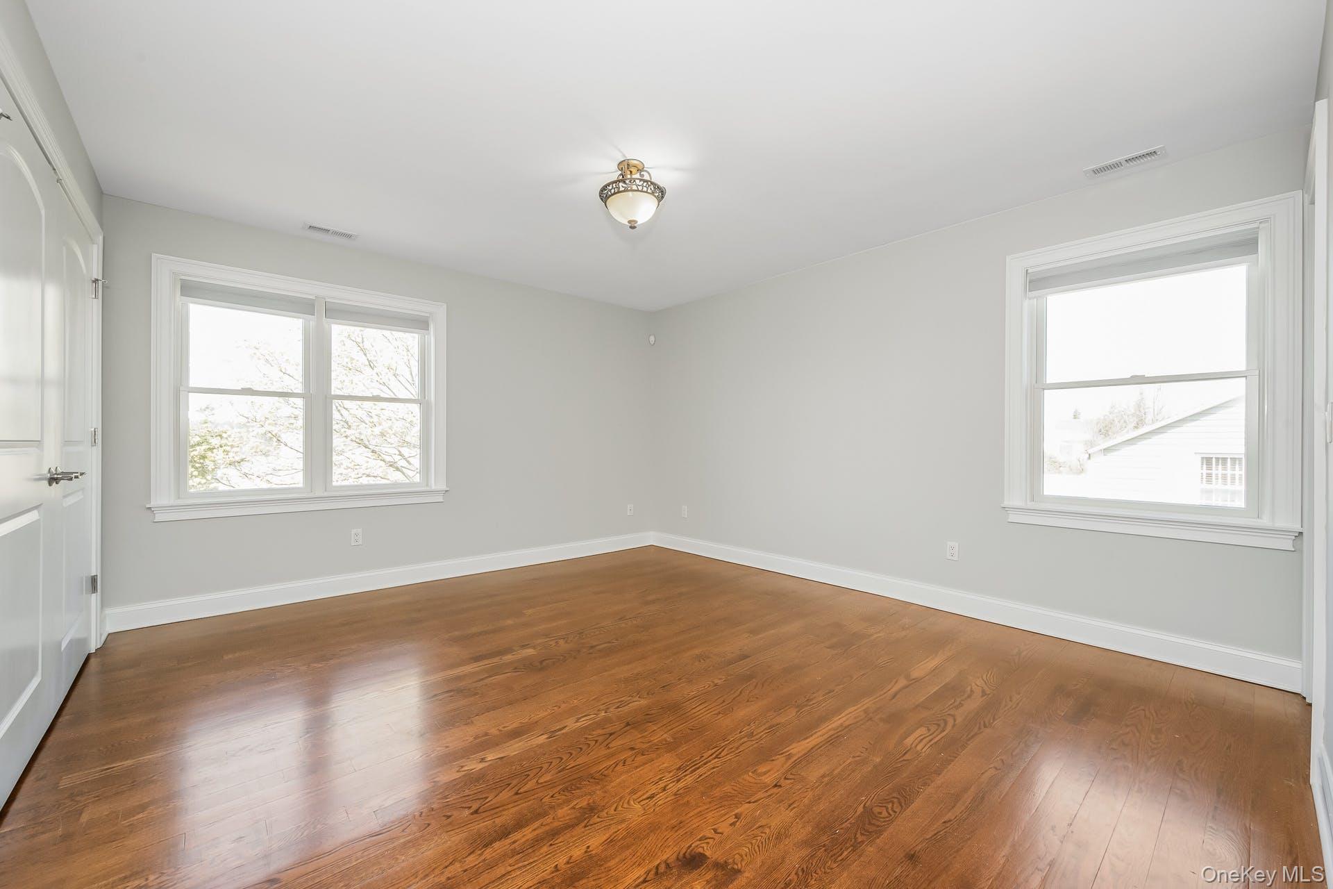 85 Park Avenue, Unit RIGHT SIDE West Harrison, NY 10604 - Photo 19 of 46 an empty room with wooden floor and windows