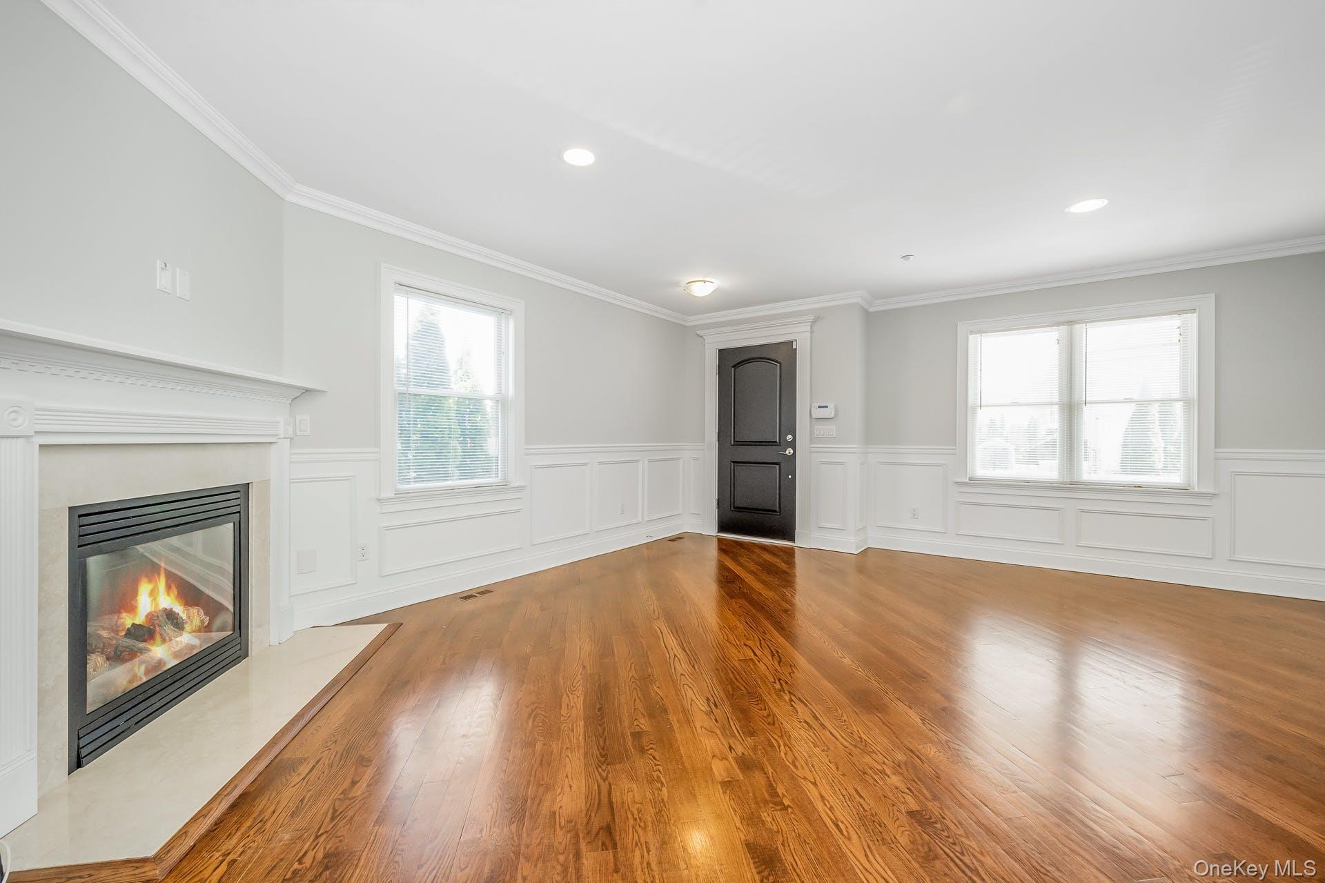 85 Park Avenue, Unit RIGHT SIDE West Harrison, NY 10604 - Photo 4 of 46 an empty room with wooden floor fireplace and windows