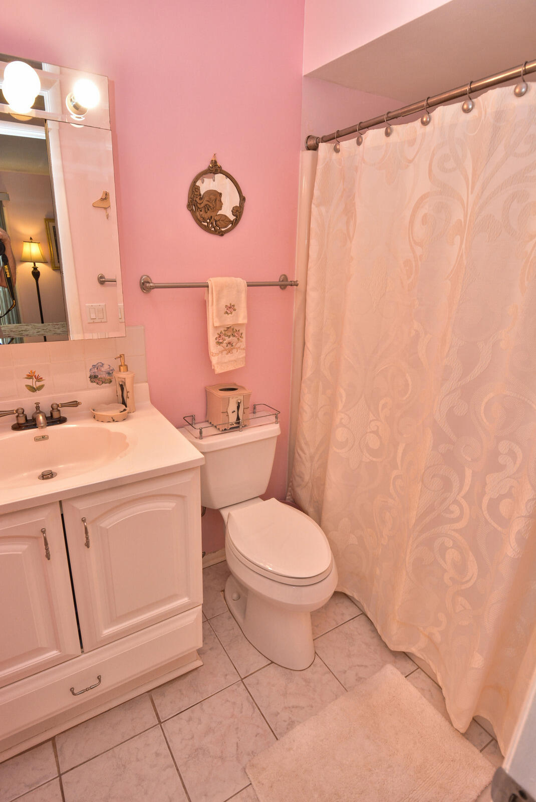 1225 Northwest 21st Street, Unit 2003 Stuart, FL 34994 - Photo 16 of 30 a bathroom with a toilet sink vanity and mirror