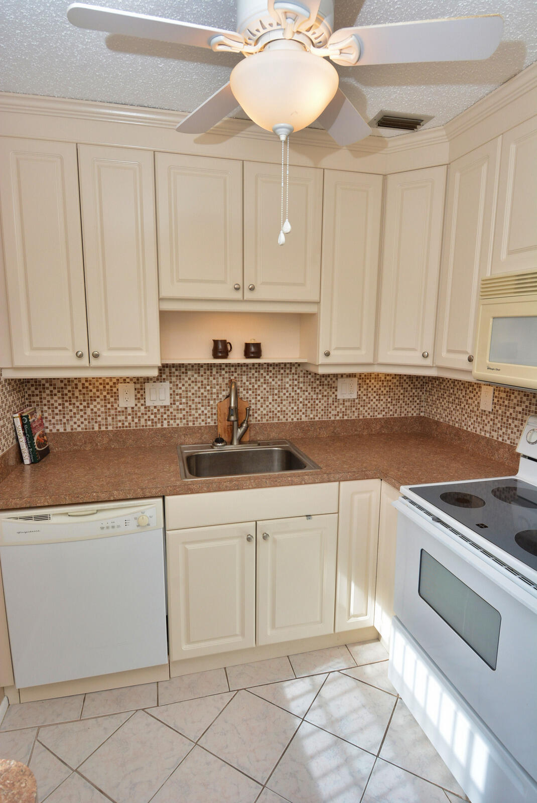 1225 Northwest 21st Street, Unit 2003 Stuart, FL 34994 - Photo 10 of 30 a kitchen with cabinets appliances and a counter top space
