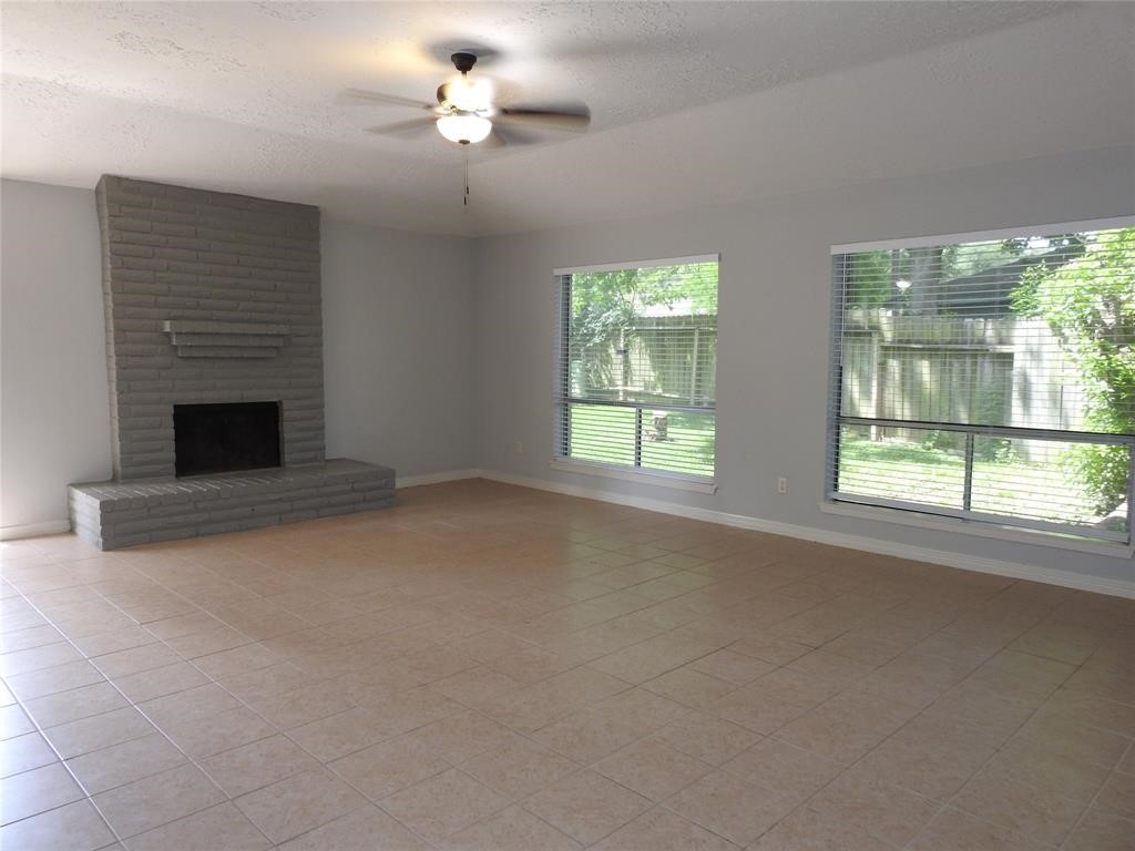 19902 Bishops Gate Lane Humble, TX 77338 - Photo 3 of 15 a view of empty room with fireplace and windows
