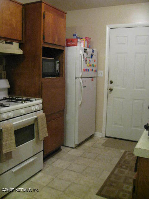 10566 Dodd Road Jacksonville, FL 32218 - Photo 4 of 19 a kitchen with a refrigerator stove and cabinets