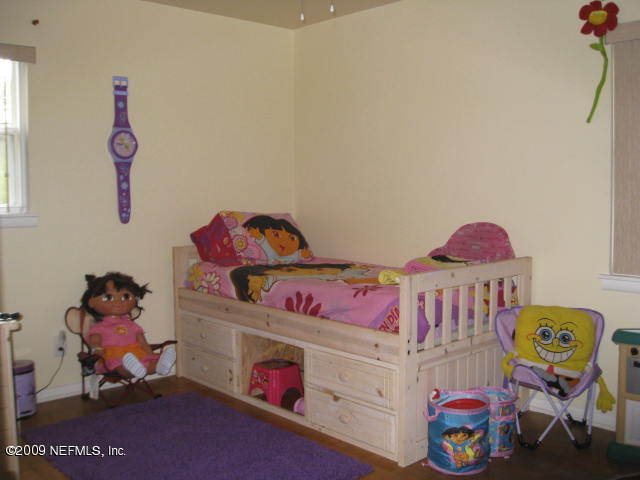 10566 Dodd Road Jacksonville, FL 32218 - Photo 9 of 19 a bedroom with toys and a wooden floor