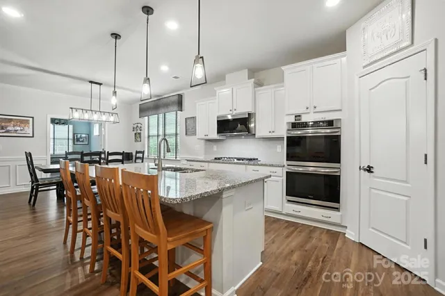 a kitchen with stainless steel appliances kitchen island granite countertop a stove a sink and a refrigerator