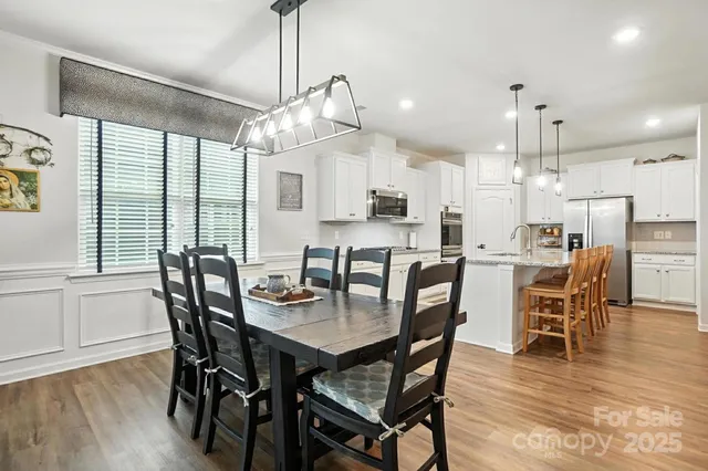 a dining room with kitchen island granite countertop a table chairs and a kitchen view