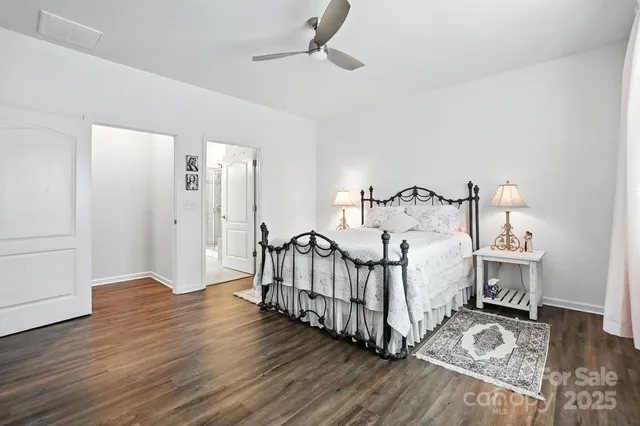 a spacious bedroom with a bed and a wooden floor