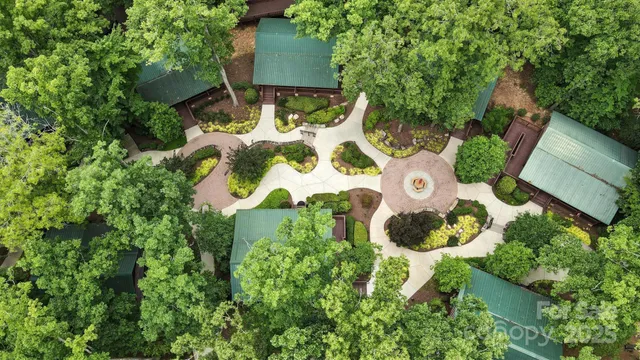 an aerial view of a house with a yard and large trees