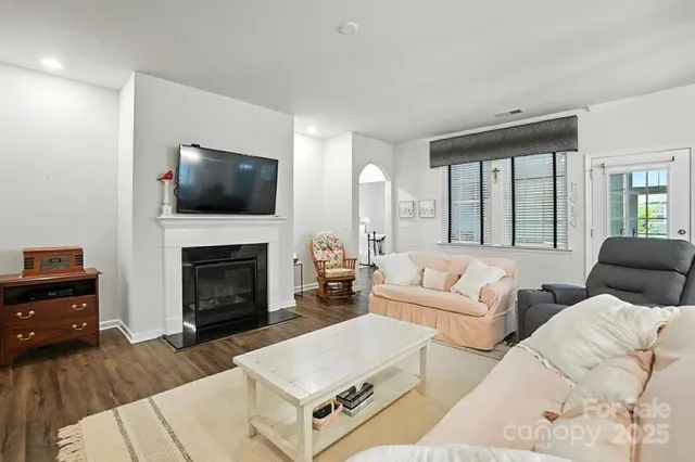 a living room with furniture a fireplace and a flat screen tv