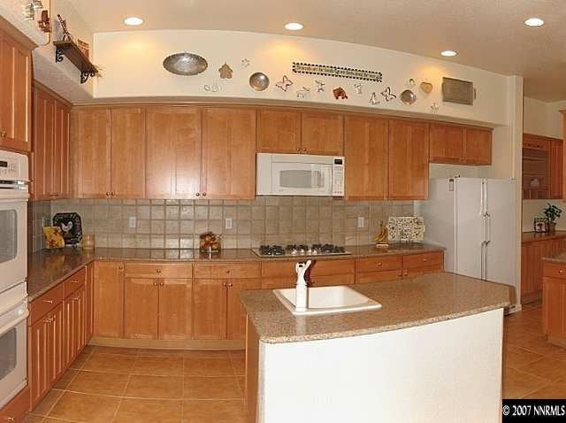 1626 Moquith Court Reno, NV 89521 - Photo 3 of 9 a kitchen with stainless steel appliances granite countertop a sink stove and refrigerator
