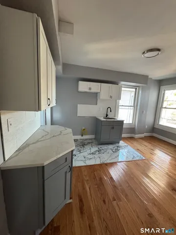 a living room with kitchen island furniture and wooden floor