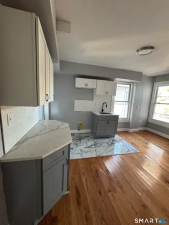 a living room with kitchen island furniture and wooden floor
