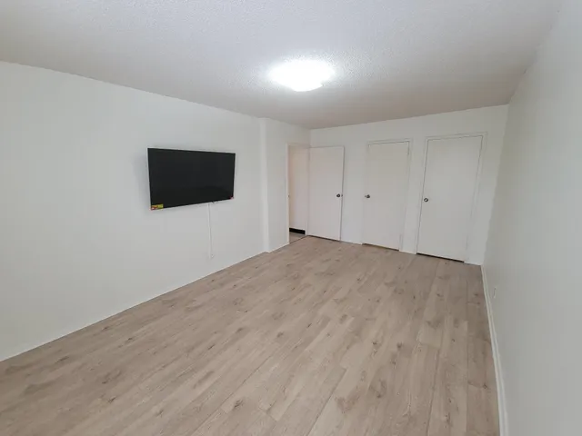 a view of a livingroom with wooden floor and a flat screen tv