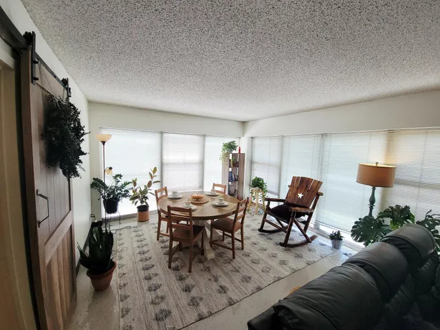an empty room with windows and ceiling fan