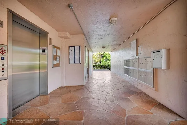 a view of a refrigerator in kitchen and an empty room