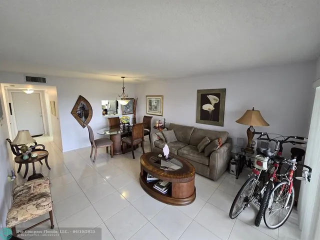 a living room with furniture dining table and a chandelier