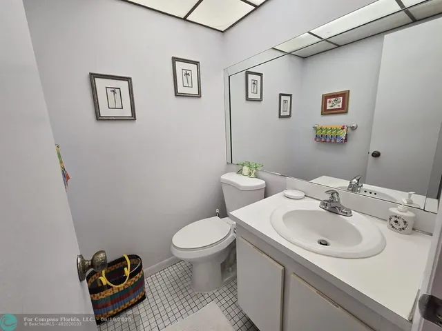 a bathroom with a granite countertop toilet sink and mirror