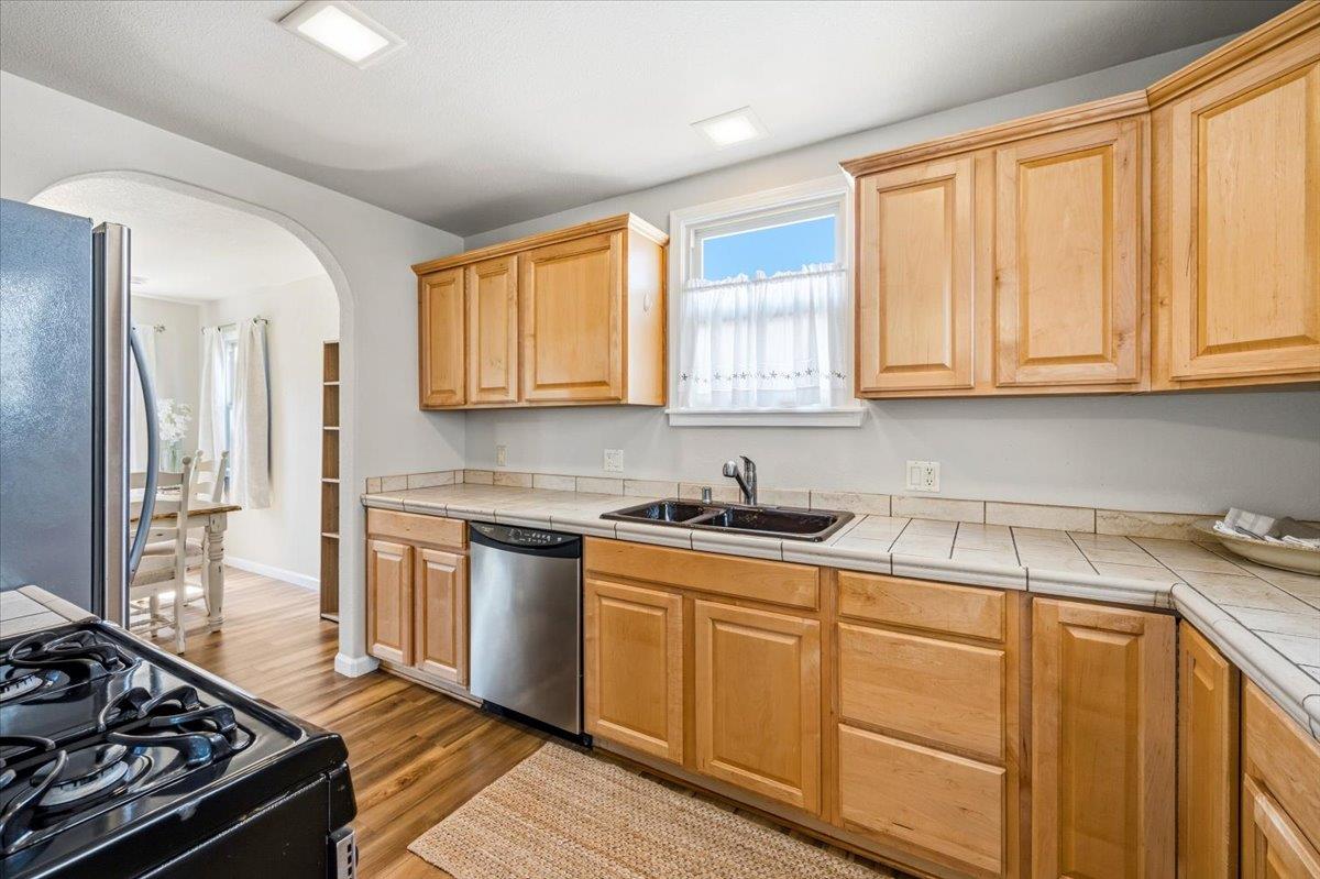 232 Upper Slate Creek Road Grass Valley, CA 95945 - Photo 11 of 48 a kitchen with granite countertop a stove a sink dishwasher and cabinets with wooden floor