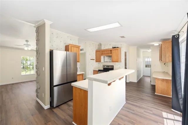 a kitchen view with a refrigerator a stove and wooden floor