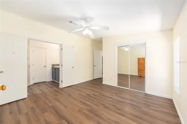 an empty room with wooden floor and closet