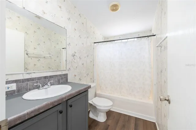 a bathroom with a granite countertop sink toilet and shower