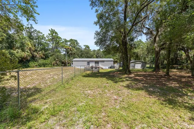 a view of a house with backyard and tree
