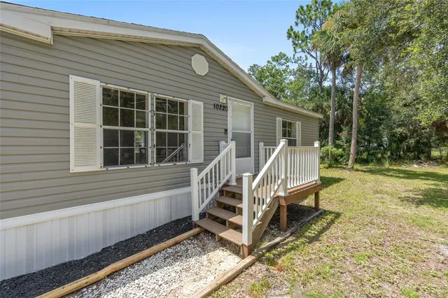 a view of house with a roof deck and chair