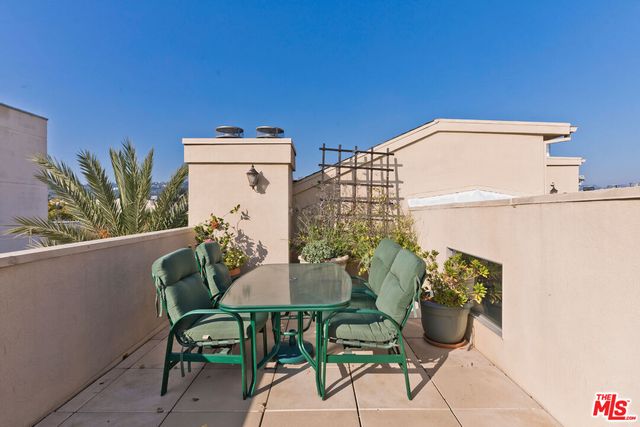 a balcony with table and chairs