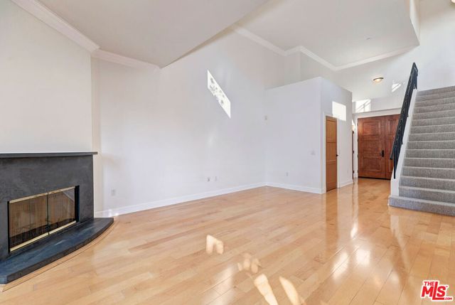a view of empty room with wooden floor and fireplace