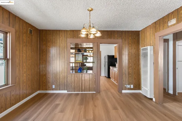 a view of a room with wooden floor kitchen view and windows