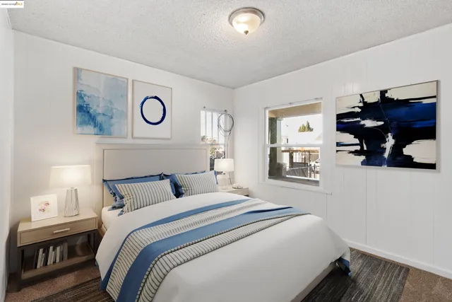 a bedroom with a bed and a lamp on dresser