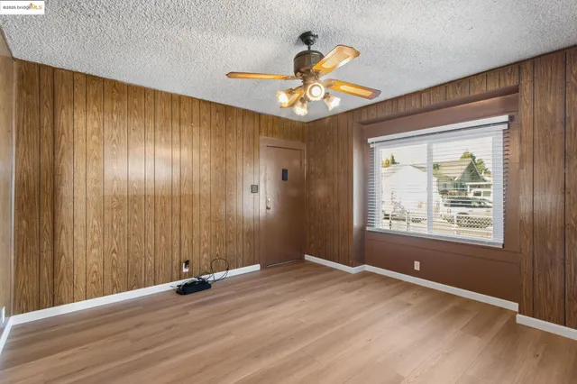 a view of an empty room with a window and a ceiling fan